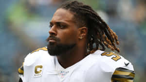 NFL美式足球員在雨中穿著帶有隊長臂章的白金色制服。