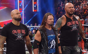 三位WWE摔角手在現場活動中站在擂台上，背景有粉絲。 — 摔角 GIF 壁紙