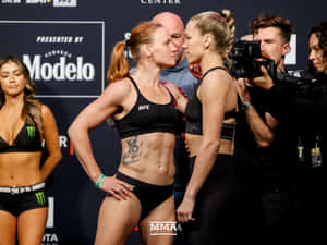 兩位女性MMA拳手在稱重活動中於比賽前鎖定眼神。 — 4:3 壁紙
