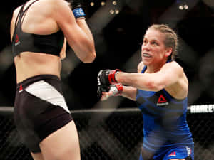 兩名女MMA拳手在八角籠內行動。 — 4:3 壁紙