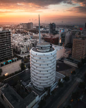 日落時分的 Capitol Records 大樓，橙色天空和城市景觀。 — 夜晚 GIF 壁紙