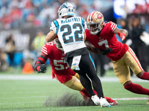 NFL美式足球運動員在球場上進行擒抱動作。