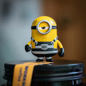 一個黃色Minion玩具公仔企喺咖啡罐蓋上。
