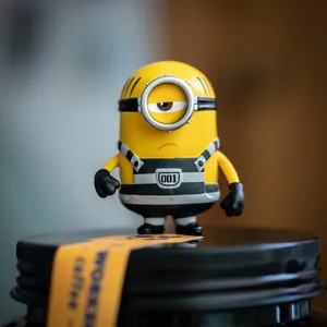 一個黃色Minion玩具公仔企喺咖啡罐蓋上。