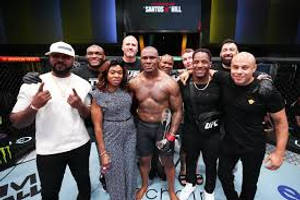 UFC拳手與團隊在八角籠內慶祝勝利。