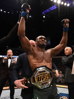UFC冠軍在八角籠內高舉雙臂慶祝勝利。