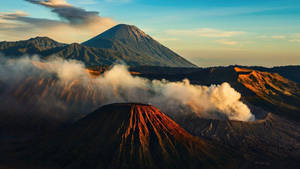 日出時火山升起蒸氣的山脈