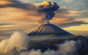 日出時火山噴發冒煙，被雲霧環繞