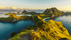金色夕陽照耀著鬱鬱蔥蔥的綠色島嶼，碧綠海水和停泊的船隻。 — 島嶼 壁紙