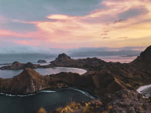 日落時的火山島，粉橙色的天空和寧靜的海水。