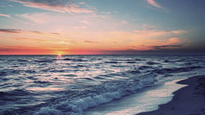 夕陽下的海洋，海浪沖刷沙灘於黃昏 — 暮光 壁紙