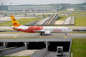 紅白貨機在機場跑道近高速公路隧道。 — 飛機 壁紙