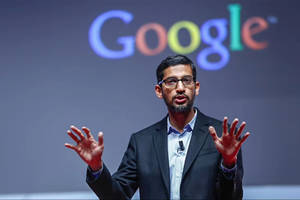 身穿西裝的男子在Google活動中發言，身後有標誌。