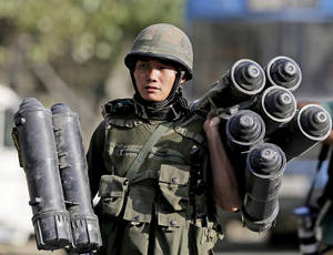 士兵在白天戶外穿著軍事裝備攜帶火箭發射器。