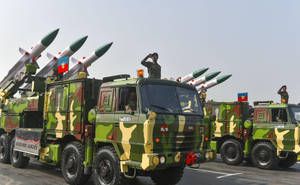 閱兵期間軍用卡車運載阿卡什導彈，士兵敬禮。