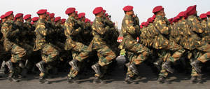 身穿迷彩服和紅色貝雷帽的士兵在閱兵中列隊行進。