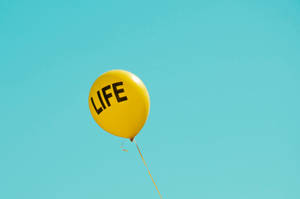 藍天中漂浮著帶有「LIFE」字樣的黃色氣球