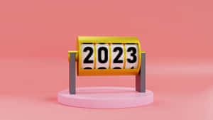 一個3D渲染的機械日曆，在粉紅色底座上顯示2023年。 — Studio Display 壁紙