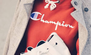 著住紅色Champion連帽衫、灰色外套同白色運動鞋嘅人。