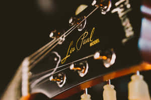 Les Paul結他琴頭特寫，金色字體和閃亮調音栓。