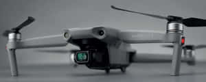 灰色DJI Mavic Air 2無人機的特寫，帶有黑色螺旋槳和綠色鏡頭。