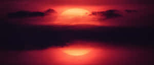 烏雲後水面倒映的紅色太陽，黃昏時分。