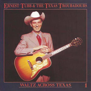 Ernest Tubb 身穿粉紅色西裝、戴白色牛仔帽，手持結他。
