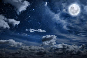 滿月在夜空中閃耀，伴隨著飄動的雲朵和星空。 — 月色夜空 壁紙