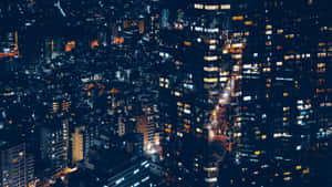 從空中視角看到的夜間城市景觀，帶有發光的窗戶和照明街道。