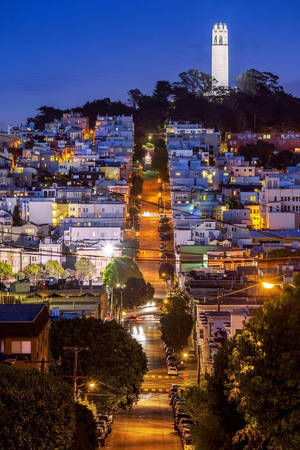 暮色中三藩市陡峭街道的景色，遠處可見科伊特塔。 — 夜景城市 壁紙