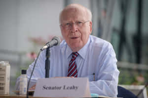 參議員 Leahy 在正式會議中發言，配有咪高峰和名牌。 — 低調 壁紙