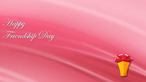 在粉紅色緞面背景上帶有禮物盒的 Happy Friendship Day 問候