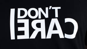 黑色T恤，白色粗體反向文字寫著「DON'T CARE」