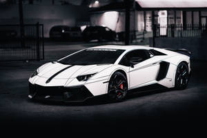 白色林寶堅尼 Aventador 帶有黑色條紋，停在黑暗的城市車庫中。