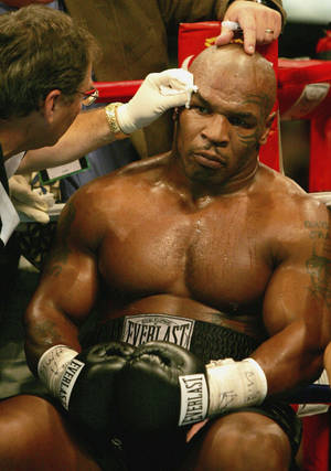 Mike Tyson 在拳擊擂台上由教練照料。