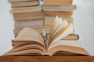 木質表面上的打開書本，後面有書堆