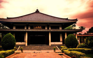 傳統東亞寺廟，擁有瓦頂和石階，在溫暖的日落天空下。