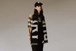 在工作室中穿著 Burberry 格紋外套和帶有字樣的大圍巾的人。