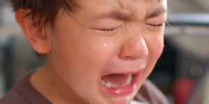 一個臉上掛著淚水的年幼孩子在哭泣。