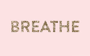 在柔和的粉紅色背景上，閃閃發光的金色文字寫著「breathe」。