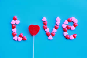 心形糖果用中間嘅紅色棒棒糖拼出 love。