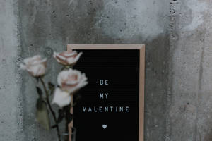 黑色字母板寫著「Be My Valentine」和心形，旁邊是粉紅玫瑰在混凝土牆上。 — 可愛情人節gif 壁紙