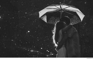一對情侶在夜雨中於傘下親密擁抱。 — 可愛情侶 GIF 壁紙