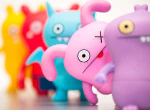 一排彩色Uglydoll玩具，其中一個粉紅色公仔在焦點上。