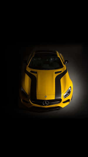 在黑暗工作室中照亮的黃色梅賽德斯-AMG GT 跑車，帶有黑色條紋。