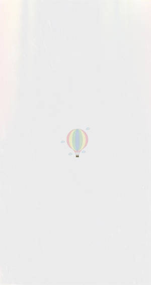 一個粉彩彩虹熱氣球在柔和天空中漂浮。