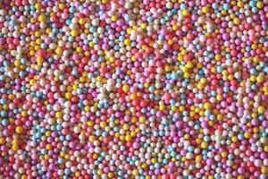 用嚟裝飾甜品嘅彩色糖珠特寫。 — 糖果 GIF 壁紙