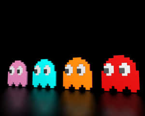 四個發光的 Pac-Man 鬼魂，分別為粉紅色、青色、橙色和紅色，排成一排。