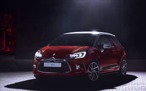 紅色 DS 3 汽車在黑暗的攝影棚中被聚光燈照亮。