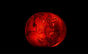 一個雕刻有鹿圖案的南瓜，在黑暗中發光。 — 南瓜 壁紙